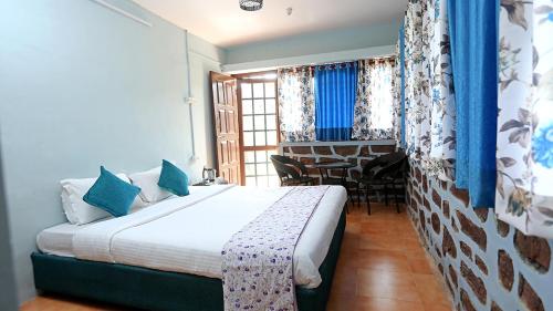 a bedroom with a bed and a table in a room at Chirping Orchard, Mukteshwar in Mukteswar