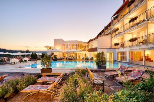 a hotel with a swimming pool with lounge chairs next to it at Berlins KroneLamm in Bad Teinach-Zavelstein