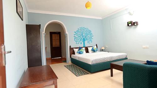 a bedroom with a bed and a table and a couch at Chirping Orchard, Mukteshwar in Mukteswar