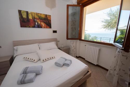 1 dormitorio con 1 cama con 2 toallas en Villa Margherita, en Torri del Benaco