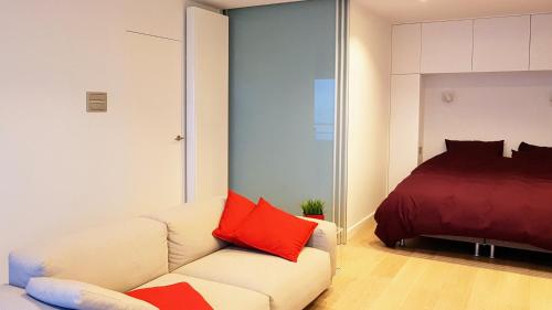 a living room with a couch and a bed at APPARTEMENT MET ZEEZICHT - de Loft in Ostend