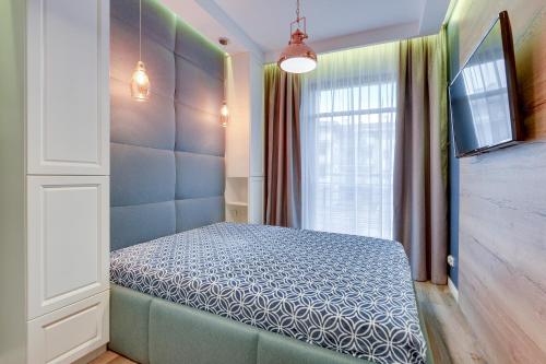 ein Schlafzimmer mit einem Bett in einem Zimmer mit einem Fenster in der Unterkunft Apartamenty Gdansk EU - Neptun Park in Danzig