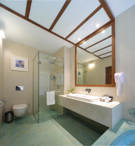 a bathroom with a sink and a shower and a toilet at Lucky Elephant Hotel in Hikkaduwa