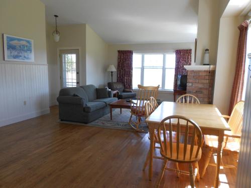 a living room with a couch and a table and chairs at Shaw's Hotel & Cottages in Brackley Beach