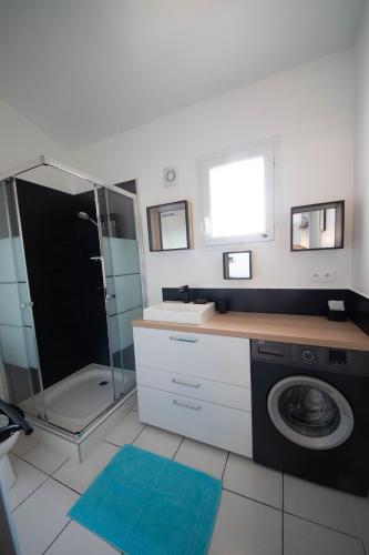 une salle de bain avec un lavabo et une machine à laver dans l'établissement Vista Mare, à Porticcio