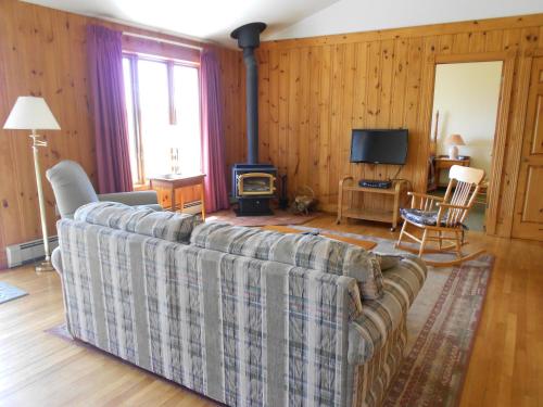 a living room with a couch and a fireplace at Shaw's Hotel & Cottages in Brackley Beach