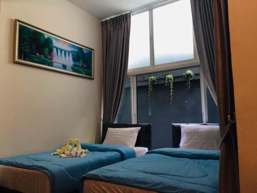 2 camas individuales en una habitación con ventana en Nineplace 46, en Bangkok