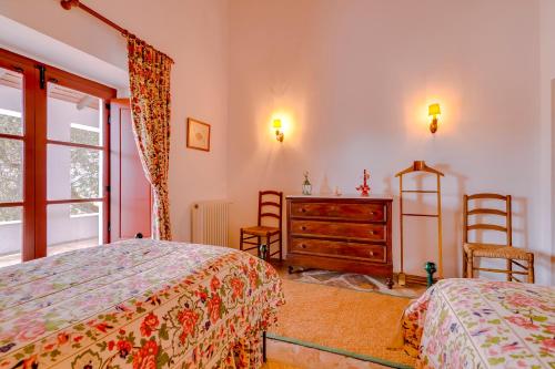 a bedroom with two beds and a dresser and a window at Monte da Lapa in Arraiolos