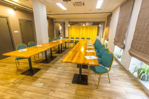 a large conference room with wooden tables and chairs at Hotel Platan in Ostrów Wielkopolski