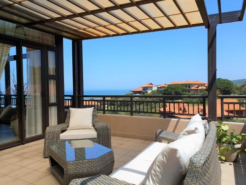 un patio con dos sillas y una mesa en Zimbali Suites 611, en Ballito