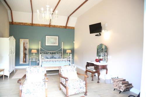 a bedroom with a bed and a table and chairs at The Highveld Cape Inn in Pretoria