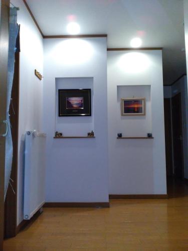 a room with a white wall with a fireplace at At Home N23 in Sapporo