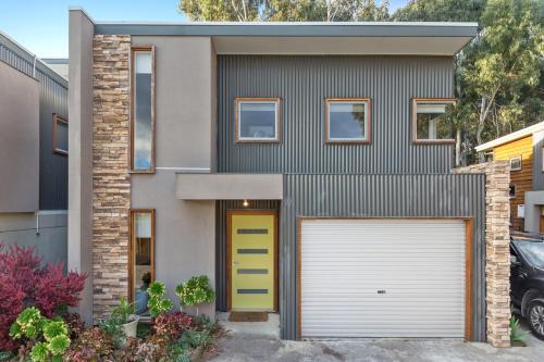 a house with a yellow door and a garage at Tangles in Ballarat