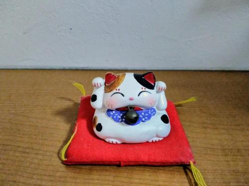 a figurine of a cat sitting on a red napkin at At Home N23 in Sapporo
