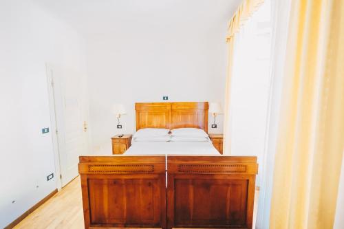 a bedroom with a bed and a wooden cabinet at Hotel Suisse in Bellagio