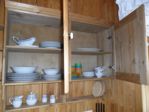 a cabinet with plates and bowls and dishes in it at Ekra Cottages in Lagarfljótsvirkjun