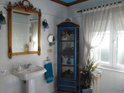 a bathroom with a sink and a blue cabinet at La Torre del Indiano-Villa- in Santander