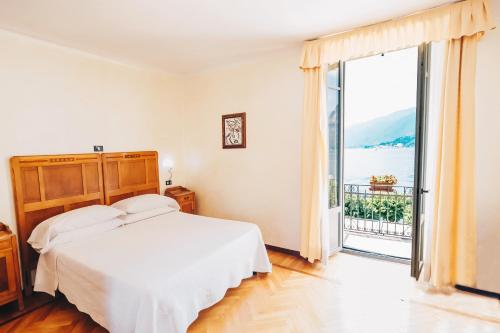 貝拉焦的住宿－蘇伊色酒店，白色的卧室设有床和大窗户