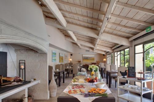 a dining room with a table with food on it at Benvengudo in Les Baux-de-Provence