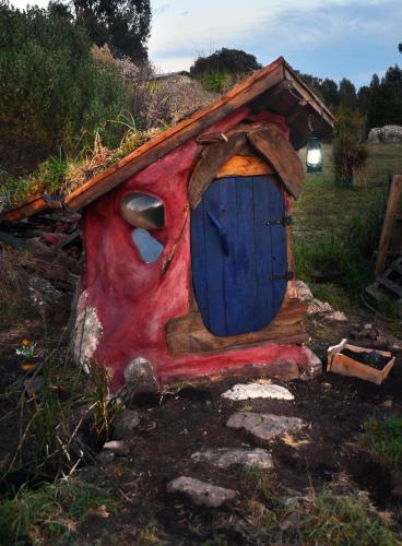 ein kleines Haus mit einer blauen Tür auf einem Feld in der Unterkunft Hobbit House in Tandil
