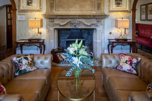 a living room with two couches and a fireplace at The Greenway Hotel & Spa in Cheltenham