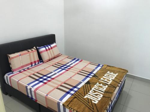 a bed with a comforter and two pillows at Spice Tunas 3B2B House in Bayan Lepas