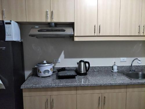 a kitchen with a sink and a counter top at The Redwoods SM Fairview by PreciousGem in Manila