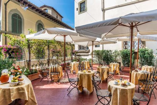 a patio with tables and chairs and umbrellas at Hotel Paris in Florence
