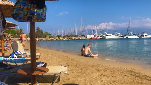 a group of people on a beach with boats in the water at Apollon Hotel in Agios Nikolaos