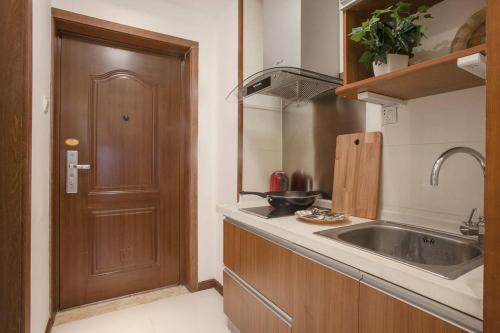 a kitchen with a sink and a wooden door at Chengdu Qingyang·Lihua Street· Locals Apartment 00116030 in Chengdu