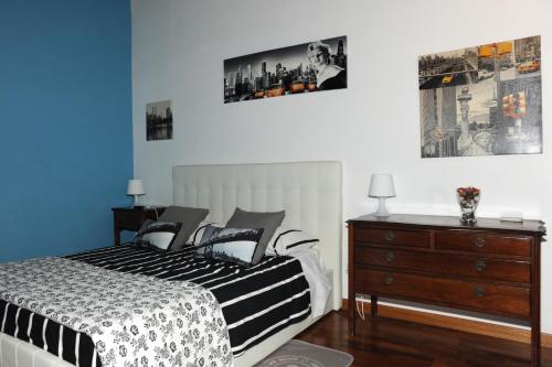 a bedroom with a black and white bed and a dresser at A CASA DI ANNA in Cerveteri