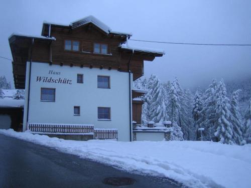 ゼルデンにあるHaus Wildschützの雪の上に看板を載せた建物