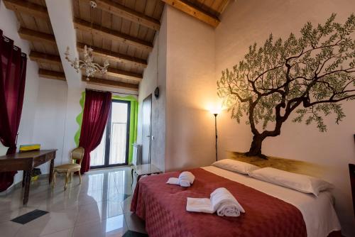 a bedroom with a tree mural on the wall at La Casa Rossa Country House in Piazza Armerina