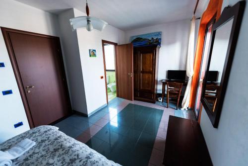a bedroom with a bed and a room with a desk at La Casa Rossa Country House in Piazza Armerina