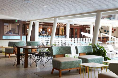 ホノルルにあるザ サーフジャック ホテル ＆ スイム クラブの椅子、テーブル、テーブル、椅子付きのレストランを併設しています。