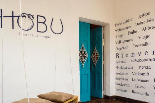 a room with a blue door and words on the wall at Hobu Hostel in Bogotá