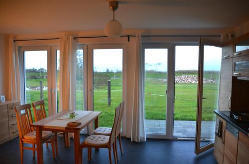 a dining room with a table and chairs and a window at Haus Calmsailing in Börgerende-Rethwisch