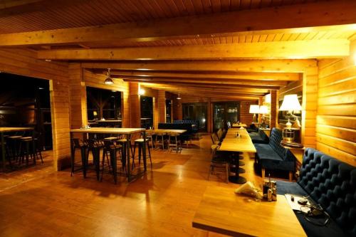 a restaurant with wooden walls and tables and chairs at LifeHarbour Limanu in Limanu