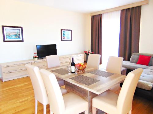 sala de estar con mesa de comedor con sillas blancas en ApartHotel Belvedere Residence Becici Budva, en Budva