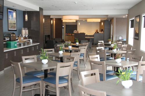a restaurant with wooden tables and blue chairs at Days Inn & Suites by Wyndham Yorkton in Yorkton
