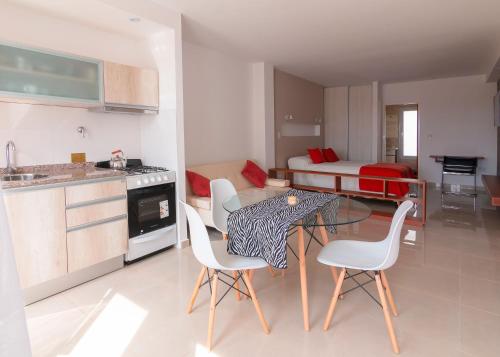 a kitchen and living room with a table and chairs at Piélago in Puerto Madryn