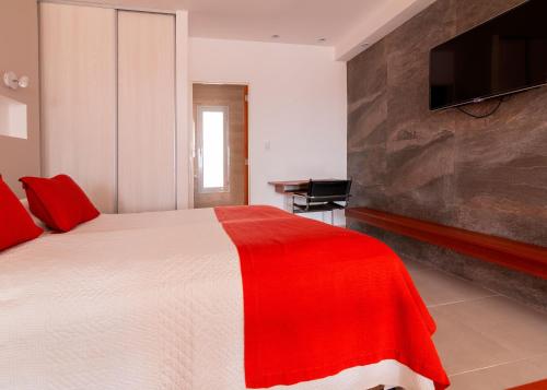 a bedroom with a red and white bed and a television at Piélago in Puerto Madryn