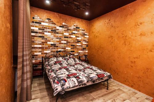 a bed in a room with a brick wall at Loft Apartment on Svobody in Kamianske