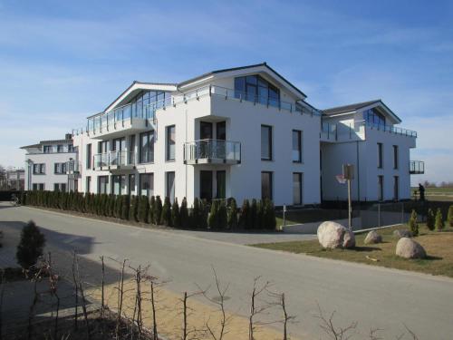 a large white building on the side of a road at Haus Calmsailing in Börgerende-Rethwisch