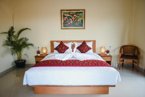 - une chambre avec un grand lit et une peinture murale dans l'établissement Deko House, à Ubud