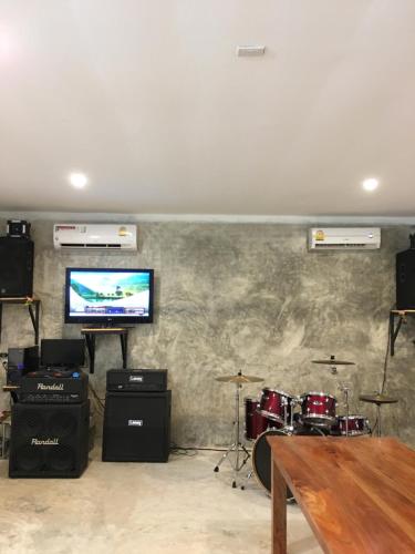 a room with a stage with drums and a television at Baan Suan Kru Kob in Ban Ko Maphang