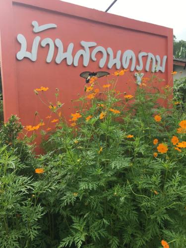 una señal para una planta con flores delante en Baan Suan Kru Kob en Ban Ko Maphang