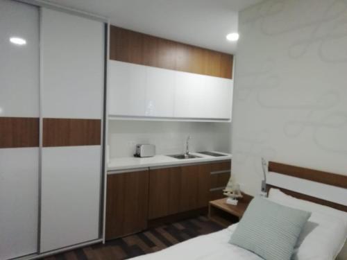 1 dormitorio con cama y lavamanos en Lukentum Suites, en Alicante