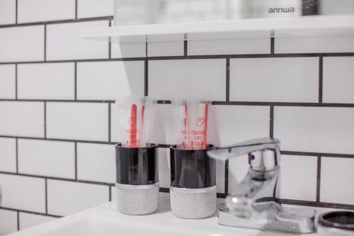 a bathroom sink with two toothbrushes on a counter at ChengDu Chenghua·Chengdu East Station· Locals Apartment 00137110 in Chengdu