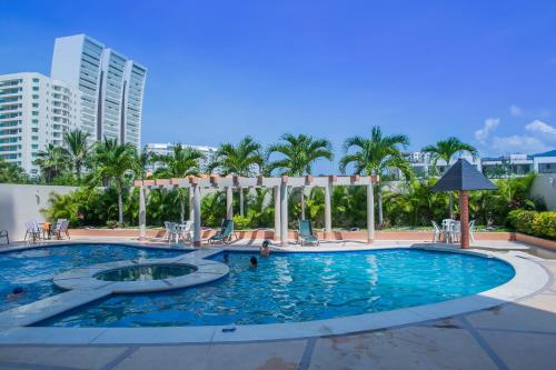 a swimming pool at a resort with palm trees at Hotel RRU Diamante in Acapulco